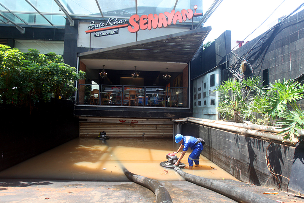 Petugas dari Dinas Sumber Daya Air (SDA) Jakarta Selatan mengoperasikan mesin pompa untuk menyedot air banjir yang menggenangi basement bangunan di Jalan Raya Kemang, Jakarta Selatan, jum'at (31/10/2025).