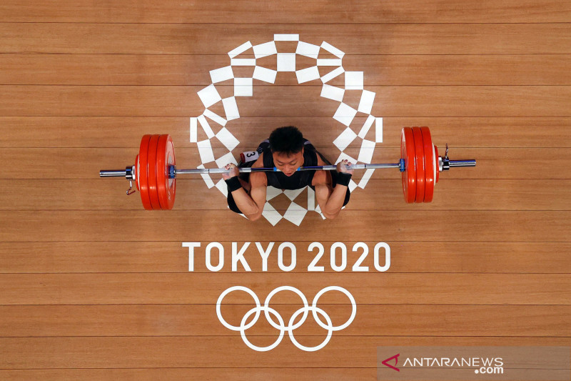 Lifter Indonesia Rahmat Erwin Abdullah melakukan angkatan di saat laga grup B angkat besi kelas 73 kg putra Olimpiade Tokyo 2020, di Tokyo International Forum, Tokyo, Jepang, Rabu (28/7). ANTARA FOTO