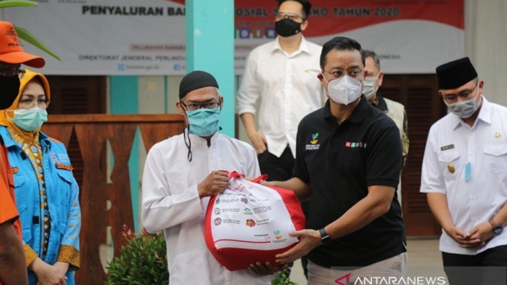 Menteri Sosial Juliari P Batubara (baju hitam) saat menyerahkan bansos sembako kepada warga terdampak COVID-19. (ANTARA/HO.Humas Kemensos)