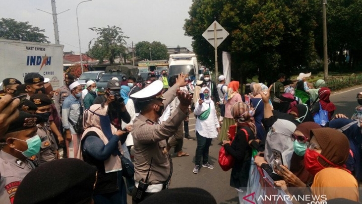 Petugas Kepolisian menghalau massa simpatisan Rizieq Shihab yang hendak berorasi di depan Pengadilan Negeri Jakarta Timur, Jumat (19/3/2021). ANTARA/Yogi Rachman
