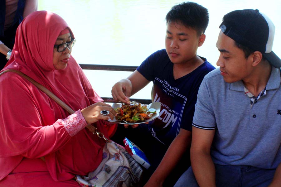 Seorang ibu bersama dengan anak-anaknya sedang menikmati rujak Pontianak. (MP/Widi Hatmoko)