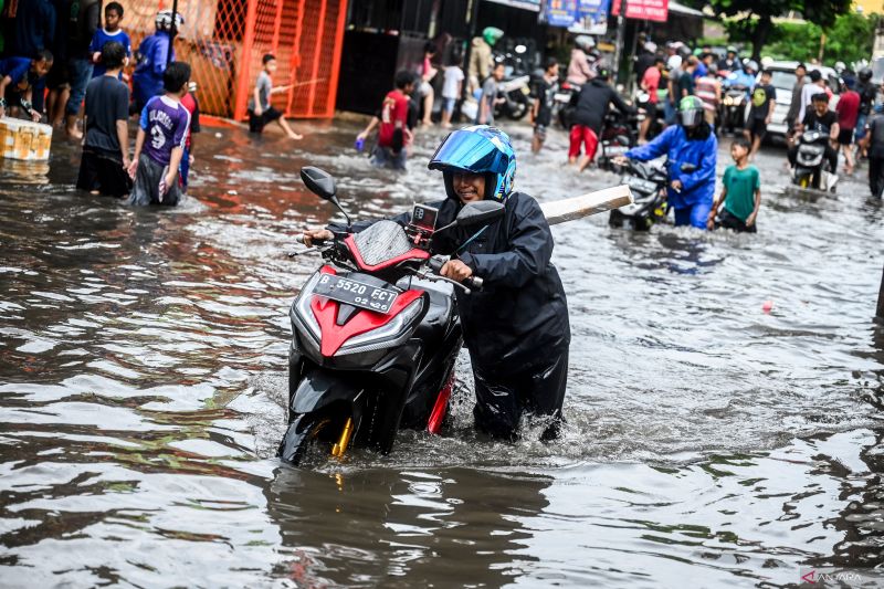 Pengendara saat mendorong motornya di Joglo, Jakarta, Jumat (22/3). Foto: Dok/ANTARA