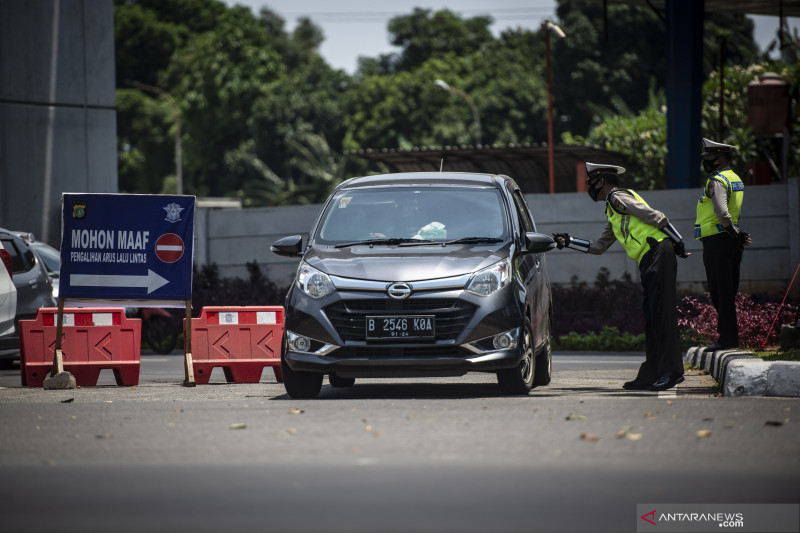 Petugas Satlantas Polres Metro Jakarta Timur memberikan imbauan kepada pengendara saat pengendalian mobilitas ganjil genap untuk pengunjung TMII di Jalan Pintu 1 TMII, Jakarta Timur, Sabtu (18/9/2021). ANTARA FOTO/Aprillio Akbar