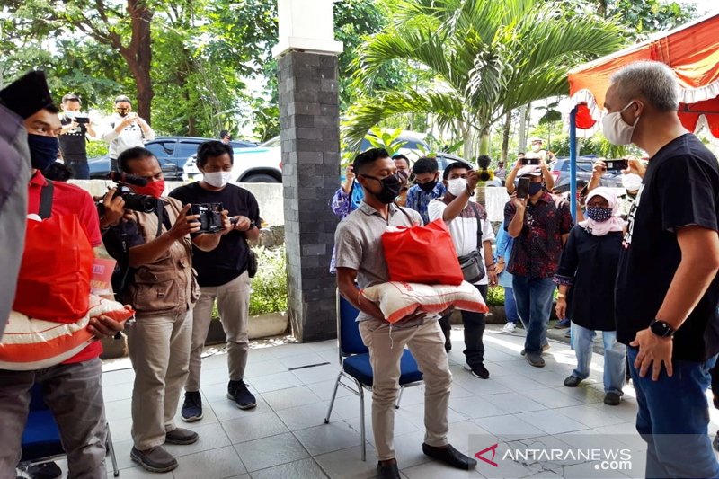 Gubernur Jawa Tengah Ganjar Pranowo (kanan) saat memberikan paket sembako kepada perwakilan buruh yang terkena PHK di Kantor DinKopnaker Boyolali, Jumat. (ANTARA/Bambang Dwi Marwoto)