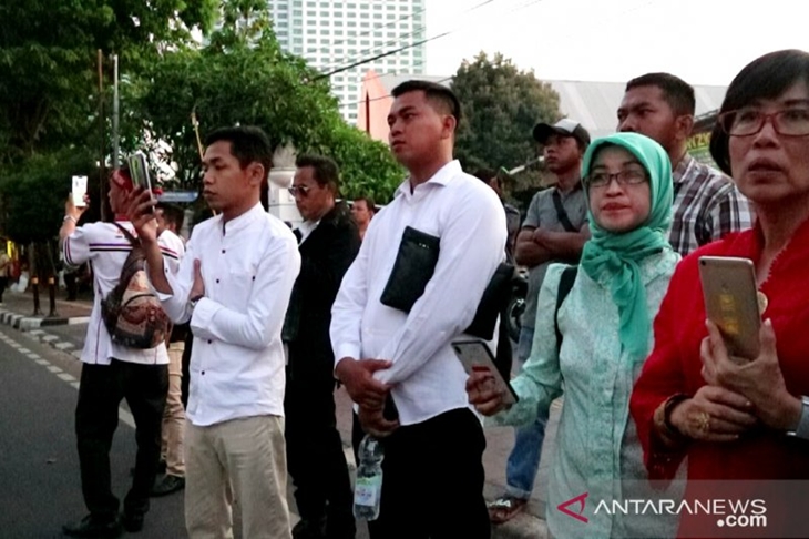 Pendukung pasangan presiden dan wakil presiden Joko Widodo-KH Ma'ruf Amin menunggu keluarnya mobil berplat RI1 di pintu belakang gedung DPR/MPR Jakarta, Minggu (20/10/2019). (ANTARA/DEVI NINDY)