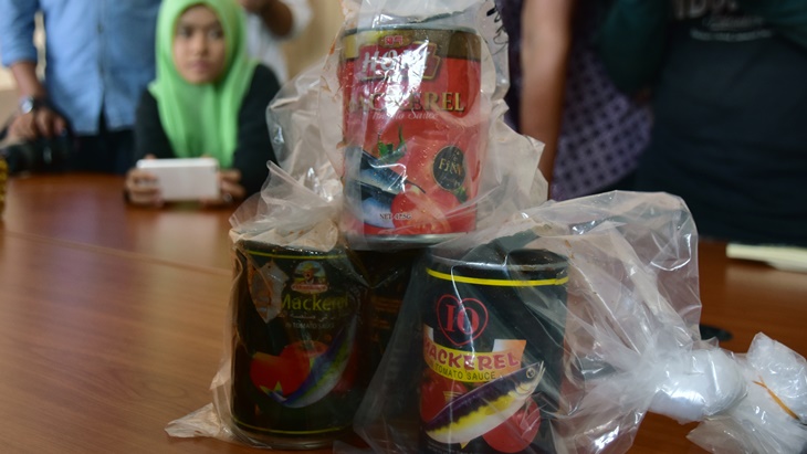 Petugas Balai Besar Pengawas Obat dan Makanan Kota Pekanbaru menunjukkan kemasan produk impor ikan. (ANTARA FOTO/FB Anggoro)