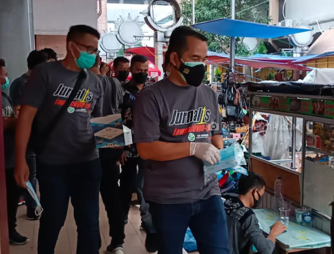 Tekan Penyebaran COVID-19, Jurnalis dan Polisi Bagikan Masker di Kawasan Pasar Baru