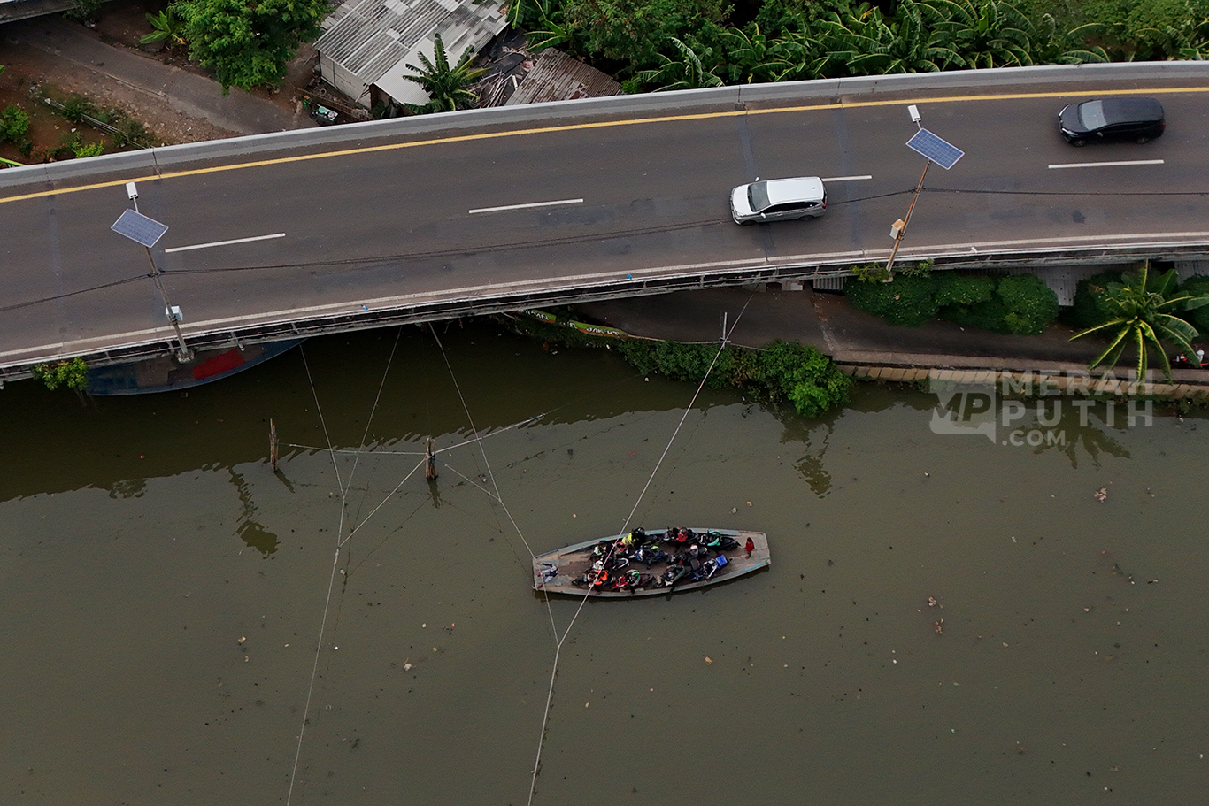 Warga Pesisir Pangkas Jarak Sebrangi Kali Angke dengan Perahu Eretan