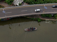 Warga Pesisir Pangkas Jarak Sebrangi Kali Angke dengan Perahu Eretan