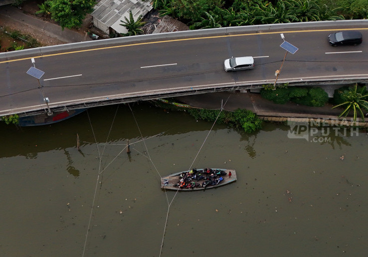 Warga Pesisir Pangkas Jarak Sebrangi Kali Angke dengan Perahu Eretan