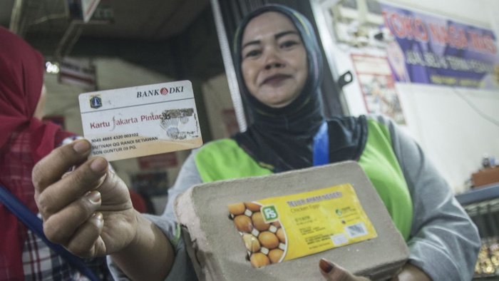 Warga menunjukan Kartu Jakarta Pintar (KJP) seusai berbelanja kebutuhan pokok menggunakan kartu tersebut di Pasar Rumput, Jakarta, Kamis (8/2/2018). ANTARA FOTO/Aprillio Akbar