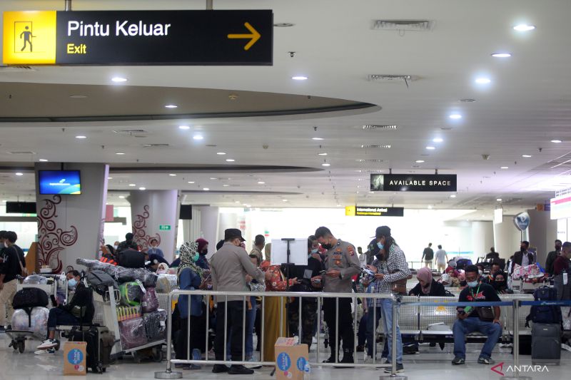Pekerja migran Indonesia (PMI) menunggu hasil pemeriksaan kesehatan dan dokumen perjalanan saat tiba di Terminal 2 Bandar Udara Internasional Juanda di Kabupaten Sidoarjo, Provinsi Jawa Timur, Sabtu (22/1/2022). (ANTARA FOTO/Umarul Faruq)