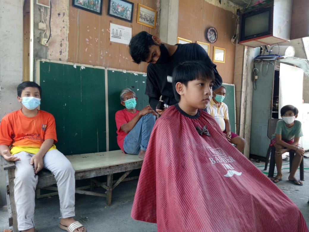Warga Solo, Jawa Tengah mengadakan aksi sosial potong rambut Rp5.000 untuk donasi warga isoman COVID-19, Rabu (11/8). (MP/Ismail)