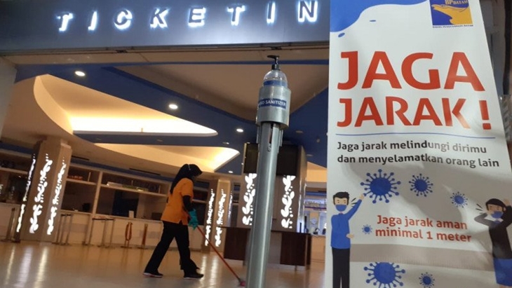 Petugas kebersihan menyapu ruang pembelian tiket di Pelabuhan Batam Centre yang lengang, beberapa hari lalu. (Foto: Antara/Naim)