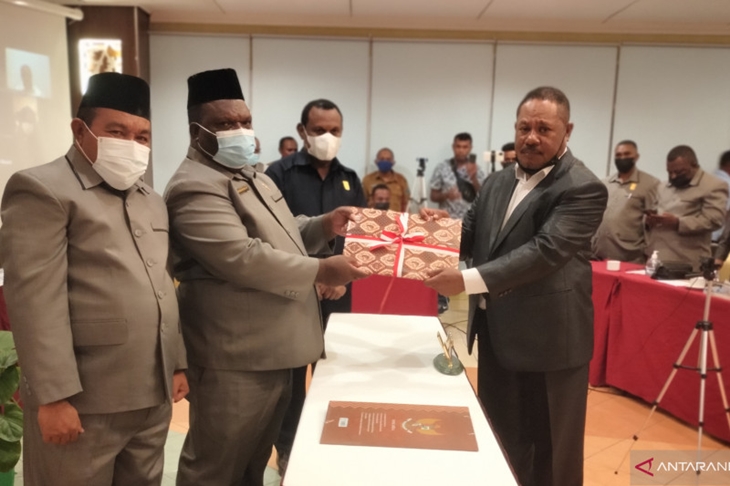 Ketua DPRP Papua Barat Orgenes Wonggor (tengah) menerima dokumen RPP Otsus Papua dari ketua Pansus Yan Anthon Yoteni, Selasa malam, di Aston Niu Hotel Manokwari. (ANTARA/HANS ARNOLD KAPISA)