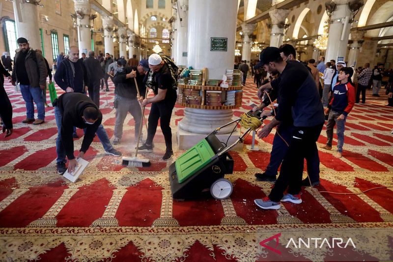 Warga Palestina membersihkan Mesjid Al-Aqsa di lapangan yang dikenal oleh Muslim sebagai "Noble Sanctuary" dan untuk Yahudi dikenal sebagai "Temple Mount" menyusul bentrok dengan pasukan keamanan Israel di Kota Tua Yerusalem, Jumat (15/4/2022). ANTARA FOTO/REUTERS/Ammar Awad