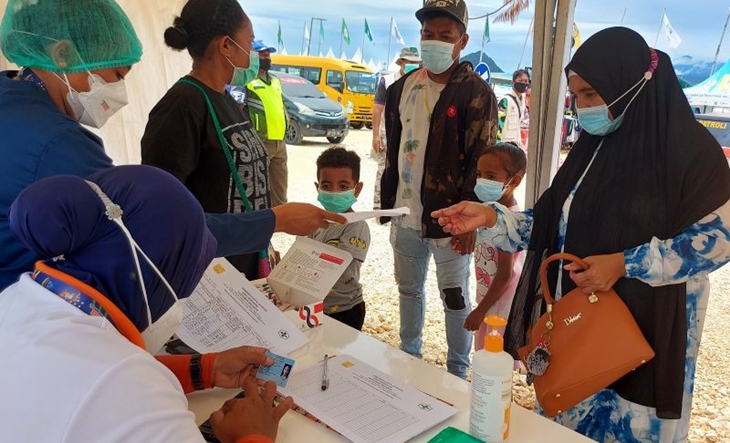 Petugas kesehatan mengecek surat vaksin dari penonton yang akan menyaksikan perlombaan dayung di Teluk Youfena, Kota Jayapura, Kamis (7/10/2021). (ANTARA/Asep Firmansyah)