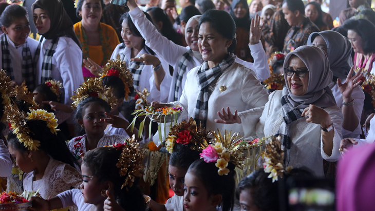 Ibu Negara Iriana Joko Widodo (kedua kanan) dan Ibu Mufidah Jusuf Kalla (kanan) menari bersama anak-anak saat kunjungan di Pendidikan Usia Dini Dharma Putra di Desa Sumerta Kelod, Denpasar, Selasa (3/4). PAUD Dharma Putra memanfatkan Balai Banjar Kedaton, Kota Denpasar sebagai sarana edukasi sekaligus pembelajaran seni sejak usia dini. ANTARA FOTO/Wira Suryantala/aww/18.