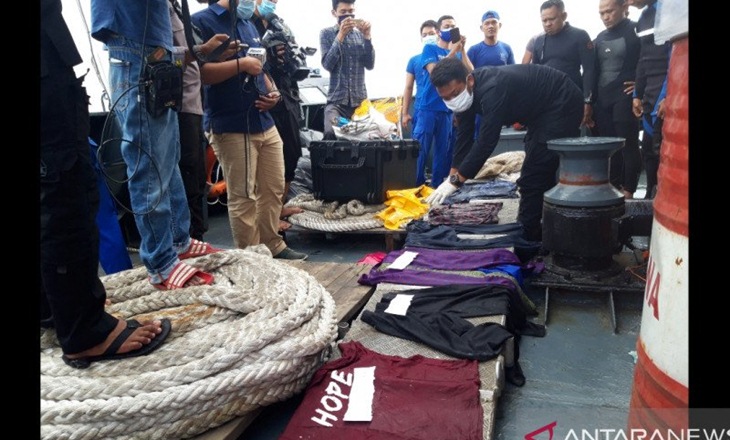 Petugas memeriksa sejumlah barang yang diduga milik penumpang dan pramugari pesawat Sriwijaya Air yang ditemukan di sekitar perairan Pulau Laki, Senin.(Antara/Muhammad Zulfikar)