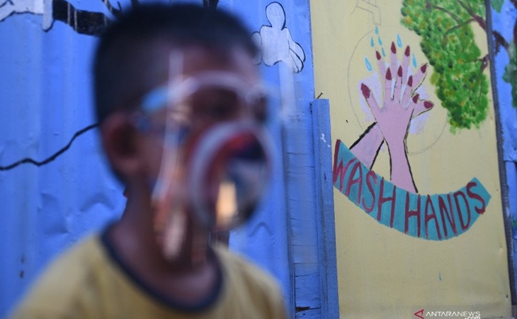 Seorang anak melintasi mural bertema COVID-19 di Jakarta, Senin (27/7/2020). ANTARA FOTO/Akbar Nugroho Gumay/pras
