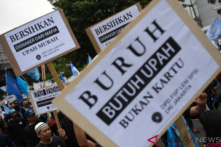Massa dari sejumlah elemen buruh melakukan aksi menuju Balai Kota Jakarta, Selasa (18/12/2018). Aksi yang diikuti ratusan buruh tersebut mendesak pemerintah merevisi upah minimum provinsi (UMP) DKI Jakarta tahun 2019 serta menolak formula PP 78 tahun 2015. ANTARA FOTO/Wahyu Putro A/aww.