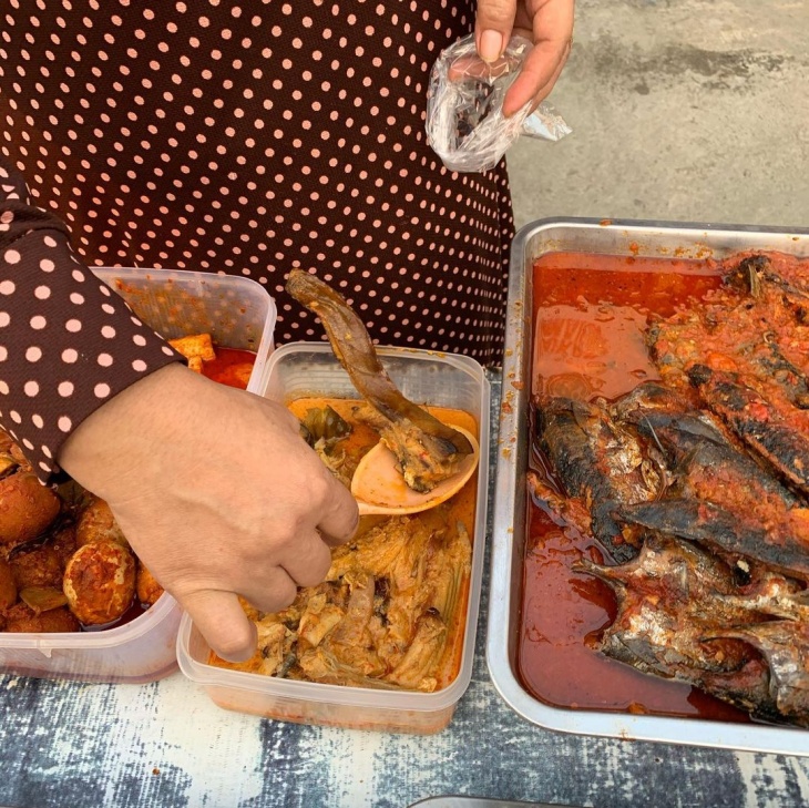 Ibu penjual takjil memasukkan makanan ke plastik minyak. (Foto Instagram/kulinergresik)