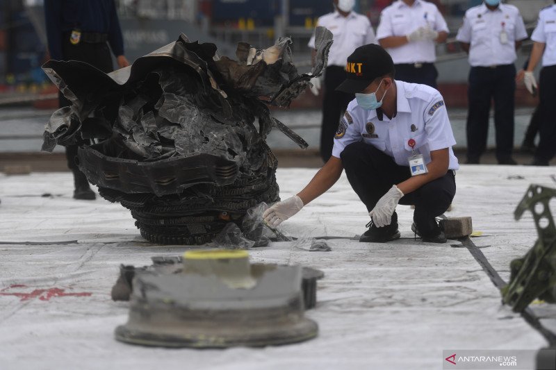 Petugas menata serpihan pesawat Sriwijaya Air SJ 182 rute Jakarta-Pontianak yang jatuh di perairan Kepulauan Seribu di Dermaga JICT, Jakarta, Senin (11/1/2021). ANTARA FOTO/Akbar Nugroho Gumay/rwa.