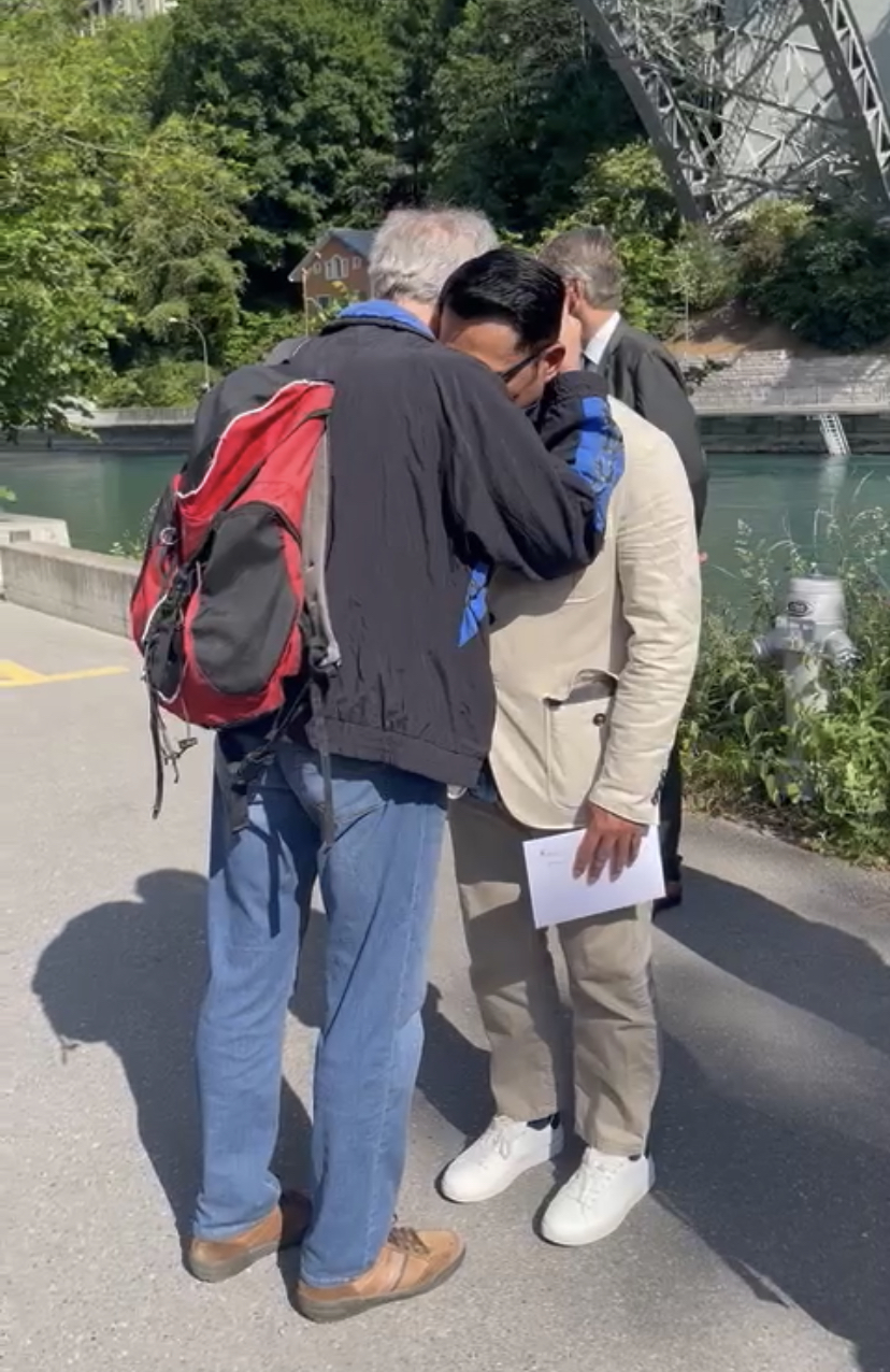 Gubernur Jawa Barat Ridwan Kamil dipeluk oleh Heinrich, penduduk Kota Bern yang membantu anak perempuannya naik ke daratan setelah berenang di Sungai Aare, Swiss, Senin (30/5/2022).