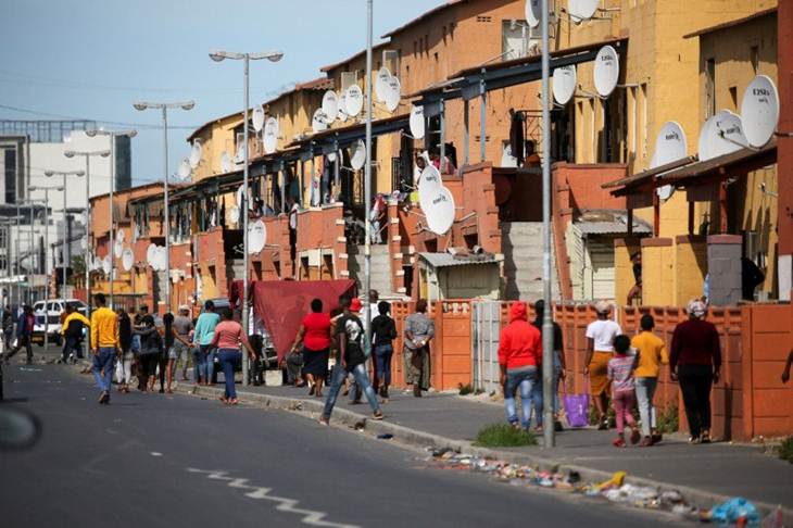 Warga berjalan di jalan di kota Langan saat "lockdown" selama 21 hari yang bertujuan membatasi penyebaran penyakit virus korona (COVID-19) mulai diberlakukan di Cape Town, Afrika Selatan, Jumat (27/3/2020). (REUTERS/SUMAYA HISHAM)