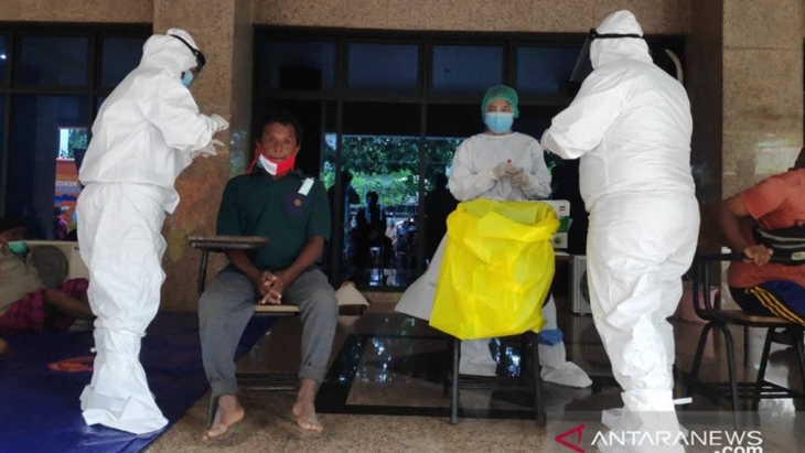 Petugas medis Polri dan TNI melakukan tes cepat antigen kepada sejumlah korban banjir yang sedang mengungsi di Aula Universitas Borobudur, Jakarta Timur, Jumat (19/2). (ANTARA/Andi Firdaus)