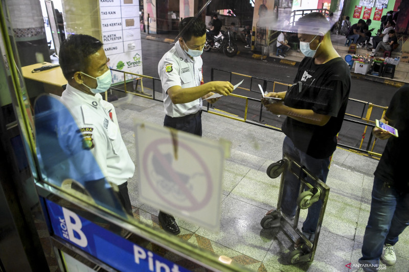Petugas memeriksa kartu vaksinasi pedagang yang akan memasuki Blok B Pasar Tanah Abang, Jakarta, Senin (26/7/2021). ANTARA FOTO/Hafidz Mubarak A/foc.