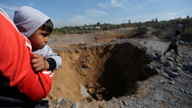 Bocah Palestina digendong melihat lokasi serangan udara Israel, di selatan kota Gaza, Minggu (18/3).(ANTARA FOTO/REUTERS/Ibraheem Abu Mustafa)