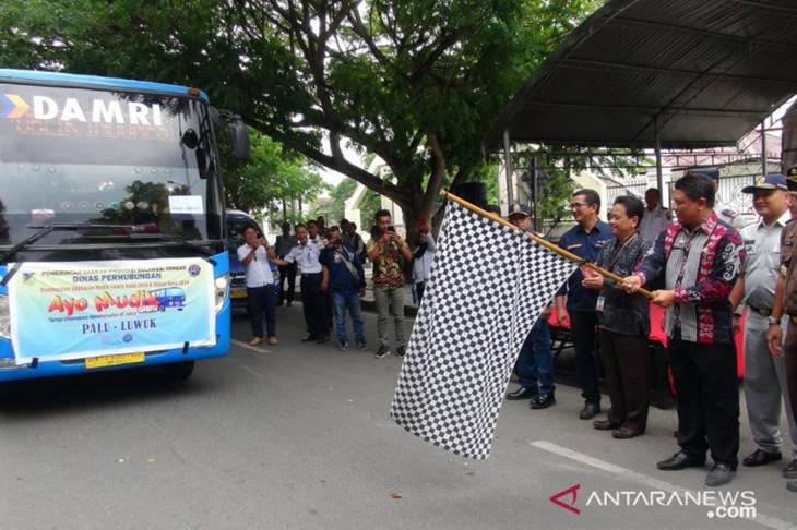 Sekdaprov Sulteng, Moh. Hidayat Lamakarate (memegang bendera) melepas pemudik Natal dan tahun baru gratis di depan Kantor Gubernur Sulteng di Kota Palu, Kamis (19/12/2019). ANTARA/HO-Humas Pemprov Sulteng