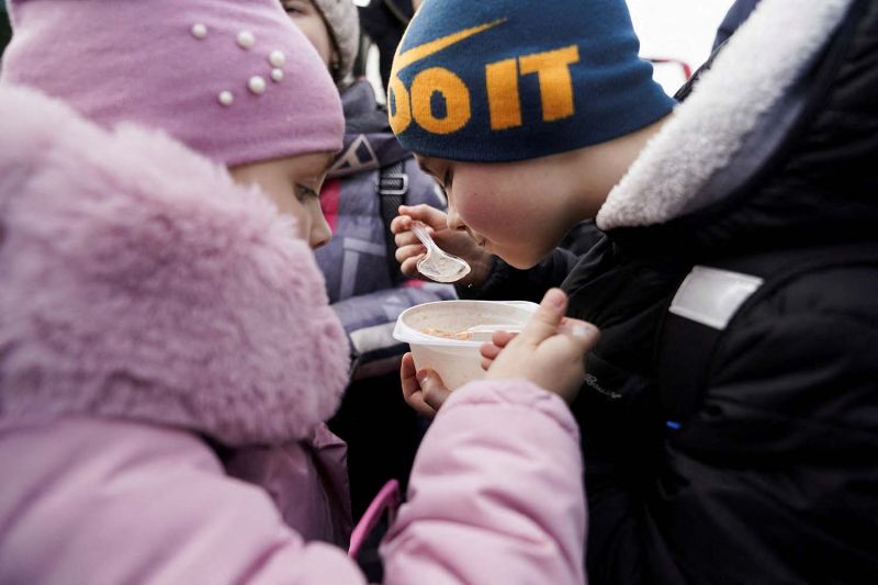 Seorang anggota Garda Perbatasan Polandia menggendong seorang anak di penyeberangan perbatasan antara Polandia dan Ukraina, setelah Rusia meluncurkan operasi militer besar terhadap Ukraina, di Medyka, Polandia (26/2/2022). (ANTARA/Reuters/Kacper Pempel/aww)