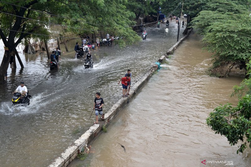 Sejumlah kendaraan melintasi banjir luapan Kali Cakung yang mulai menyusut di jalan menuju Perumahan Duta Kranji, Bekasi, Jawa Barat, Rabu (26/2/2020). Menurut keterangan warga, pada Selasa (25/2/2020) ketinggian air yang menggenangi jalan tersebut mencapai satu meter. ANTARA FOTO/Suwandy/wsj.