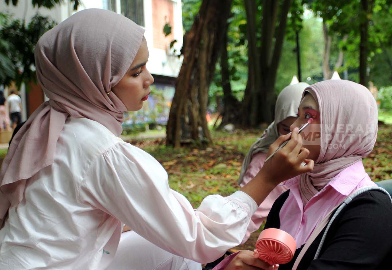 Suasana mahasiswi melayani jasa rias wajah atau make-up untuk Blink atau penggemar Girl Band asal Korea Selatan BlackPink sebelum konser di Kawasan Stadion Utama Gelora Bung Karno (SUGBK), Senayan, Jakarta, Sabtu (01/11/2025).