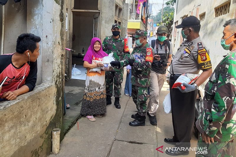 Anggota TNI dari Kodim 0504/Jakarta Selatan bersama anggota Kepolisian menyalurkan bantuan paket sembako kepada keluarga prasejahtera terdampak pademi COVID-19 di Kecamatan Mampang, Jakarta Selatan, Selasa (7/4/2020). ANTARA/HO-Kodim 0504/Jakarta Selatan/aa.