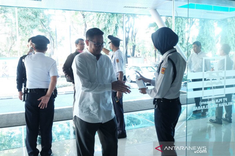 Pengecekan suhu tubuh dan penggunaan penyanitasi tangan oleh karyawan di pintu masuk PLN UIW Sulselrabar, Selasa (16/03/2020). ANTARA Foto/HO-Humas PLN