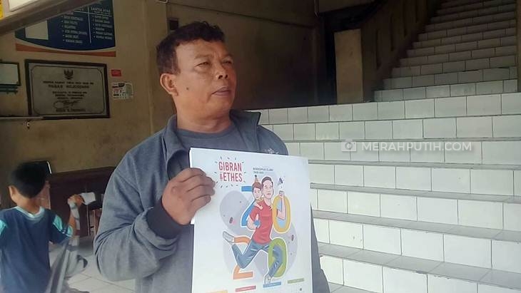 Warga Solo menunjukkan kalender yang dibagikan bakal calon Wali Kota Solo Gibran Rakabuming Raka saat blusulan di Pasar Mojosongo, Rabu (18/12). (Foto: MP/Ismail)