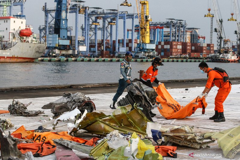 Petugas membawa kantong jenazah berisi objek temuan dari lokasi jatuhnya pesawat Sriwijaya Air nomor penerbangan SJ 182 rute Jakarta-Pontianak, di Dermaga JICT, Tanjung Priok, Jakarta, Sabtu (16/1/2021). Operasi SAR tersebut memasuki hari kedelapan. ANTARA FOTO/Rivan Awal Lingga/hp.