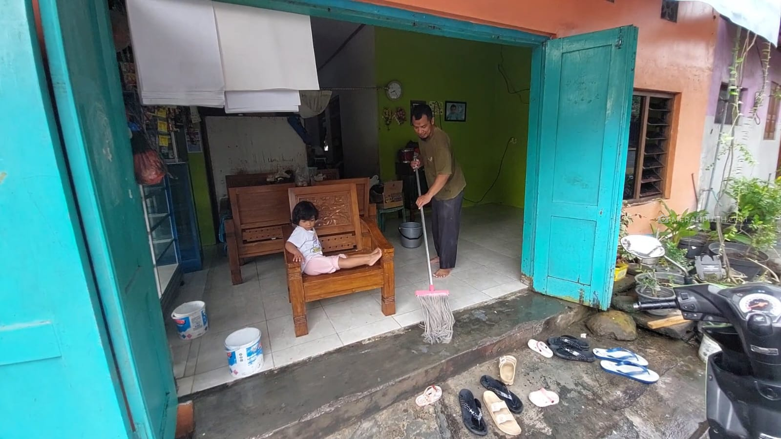 Warga Joyotakan, Solo membersihkan rumah pasca banjir surut, Sabtu (18/2). (MP/Ismail)