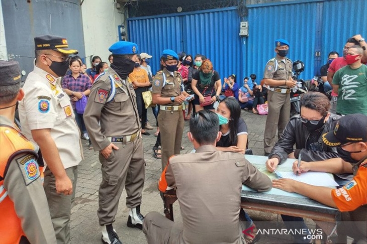 Suasana pendataan pengunjung dan pekerja usai penggerebekan Diskotek Top One, Daan Mogot 1, Jakarta Barat, Jumat (3/7/2020) pagi. Top One terindikasi beroperasi di tengah masa Pembatasan Sosial Berskala Besar (PSBB) Transisi fase 1 akibat pandemi COVID-19. ANTARA/Ricky Prayoga/aa.