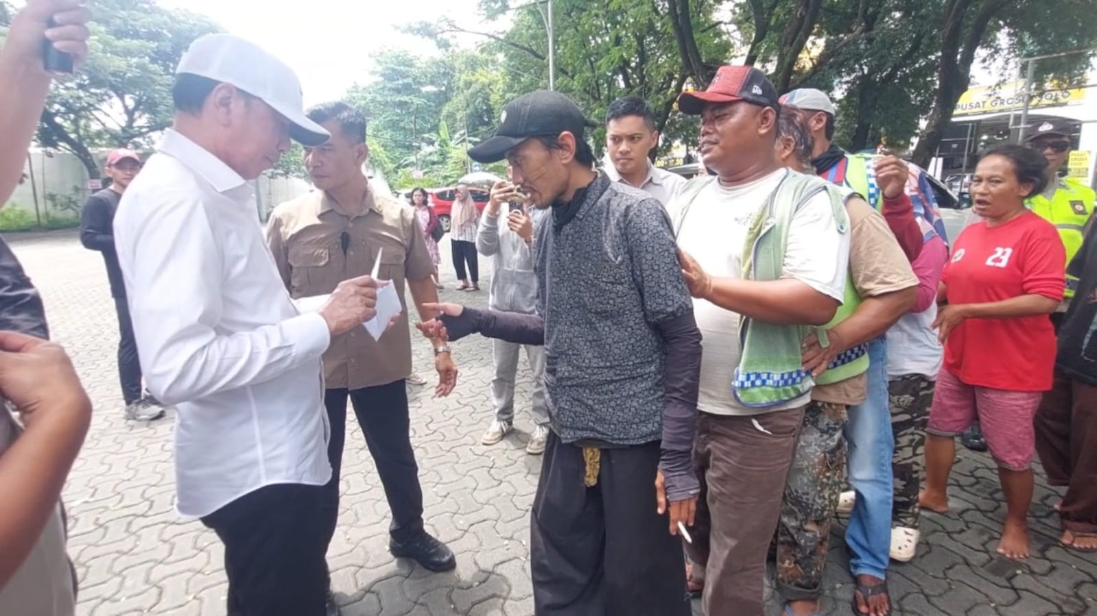 Jokowi Bagikan Paket Sembako dan Uang Tunai kepada Ratusan Tukang Becak di Solo.