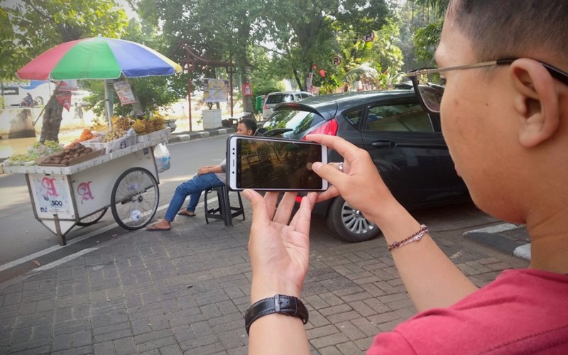 Penggemar fotografi memanfaatkan lenggangnya jalan raya untuk berfoto