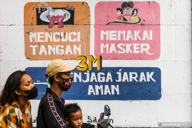 Pengendara melintas di dekat mural bertemakan COVID-19 di Petamburan, Jakarta, Rabu (21/7/2021). Berdasarkan data Kemenkes RI, pada hari pertama perpanjangan Pemberlakuan Pembatasan Kegiatan Masyarakat (PPKM) kasus COVID-19 di Indonesia kembali menurun dari 38.325 orang menjadi 33.772 orang per hari. ANTARA FOTO/Rivan Awal Lingga/foc.