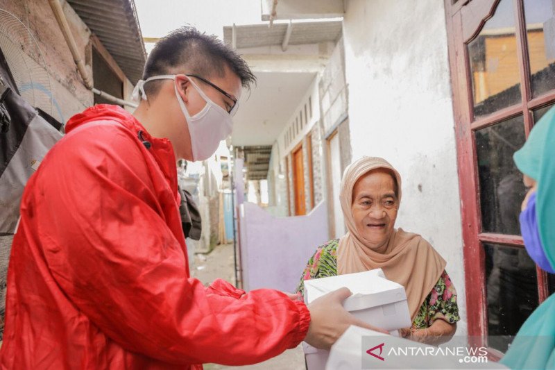 Ketua Dewan Pimpinan Wilayah (DPW) PSI DKI Jakarta, Michael Victor Sianipar saat memberikan makanan siap saji kepada warga yang terdampak COVID-19, di Jakarta. (ANTARA/HO-DPW PSI DKI Jakarta)