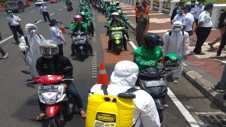 Tertib, Ratusan Ojol Antre Semprotan Disinfektan Gratis di Pinggir Jalan
