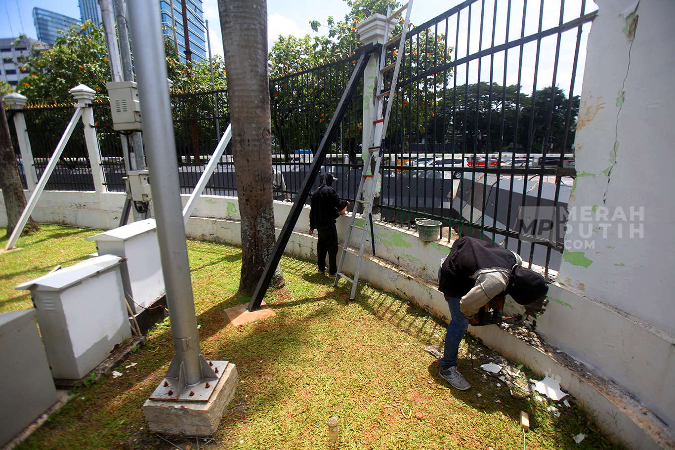 Pekerja memperbaiki pagar depan Kompleks Parlemen yang roboh di Gedung DPR, Senayan, Jakarta, Jumat (21/3/2025).