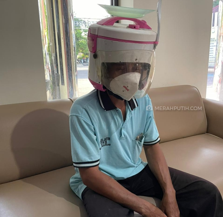 Adrai (43) dengan helm rice cooker-nya saat di kantor Satlantas  Polres Pasuruan Kota. (Foto: MP/Budi Lentera)