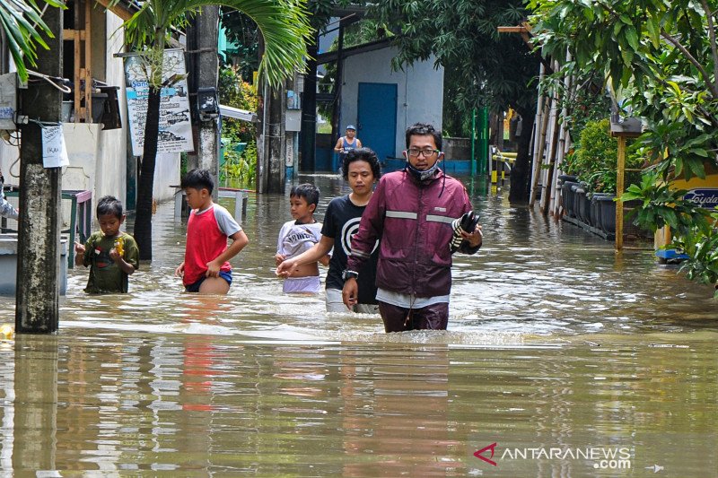 Warga melintasi banjir di perumahan Pondok Hijau Permai, Bekasi, Jawa Barat, Minggu (7/2/2021). Menurut warga, banjir setinggi 20 cm hingga 1 meter tersebut terjadi akibat curah hujan tinggi. ANTARA FOTO/ Fakhri Hermansyah/aww.